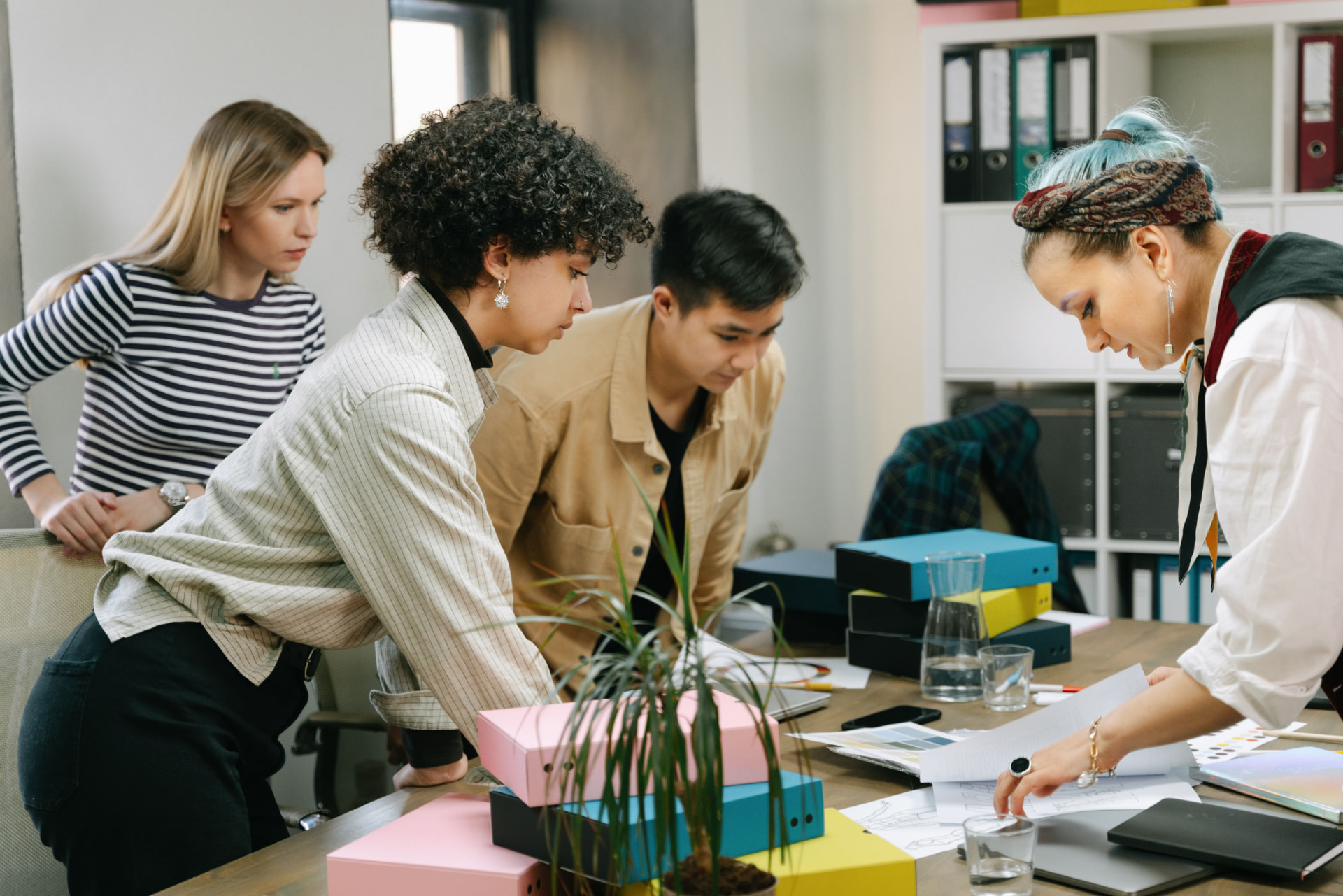 Equipe colaborando no dia a dia, com os valores da empresa ao fundo